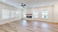 Located in Graymoor-Devondale, Kentucky, this two-story, 4-bedroom, 4-bathroom home offers a thoughtfully designed layout spread evenly across two floors. The main level features an open-concept kitchen and living area anchored by a sleek linear fireplace with a wood mantel, large windows with blinds, and light hardwood-style flooring throughout. The kitchen is a standout, boasting white shaker cabinetry, a subway tile backsplash, stainless steel appliances, and a two-tone center island with a white countertop and navy blue base, illuminated by stylish pendant lighting. The living area is bright and airy, enhanced by recessed lighting and a ceiling fan. A dedicated entrance, hallway, and laundry room add everyday convenience. Upstairs, the four bedrooms feature plush carpet flooring and ceiling fans. The generously sized primary bedroom includes walk-in closet space with built-in shelving. The bathrooms are finished with granite countertops, dual undermount sinks, vertically laid white tile surrounds, soaking tubs, and glass-enclosed showers. Three closets provide ample storage throughout, completing this clean, modern home.