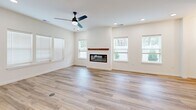 Located in Graymoor-Devondale, Kentucky, this two-story, 4-bedroom, 4-bathroom home offers a thoughtfully designed layout spread evenly across two floors. The main level features an open-concept kitchen and living area anchored by a sleek linear fireplace with a wood mantel, large windows with blinds, and light hardwood-style flooring throughout. The kitchen is a standout, boasting white shaker cabinetry, a subway tile backsplash, stainless steel appliances, and a two-tone center island with a white countertop and navy blue base, illuminated by stylish pendant lighting. The living area is bright and airy, enhanced by recessed lighting and a ceiling fan. A dedicated entrance, hallway, and laundry room add everyday convenience. Upstairs, the four bedrooms feature plush carpet flooring and ceiling fans. The generously sized primary bedroom includes walk-in closet space with built-in shelving. The bathrooms are finished with granite countertops, dual undermount sinks, vertically laid white tile surrounds, soaking tubs, and glass-enclosed showers. Three closets provide ample storage throughout, completing this clean, modern home.