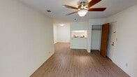 Located at 5425 Snyder Lane in Rohnert Park, California, this single-floor unit offers a thoughtfully designed layout with a comfortable blend of functional spaces and inviting finishes. The living area serves as the heart of the home, highlighted by a classic brick-surround fireplace, a ceiling fan with light fixture, and durable hardwood-style flooring that flows throughout the main living spaces. Sliding glass doors open to a private balcony overlooking lush, mature trees, filling the room with natural light and a peaceful outdoor connection. The kitchen features white cabinetry, white appliances including a range and refrigerator, and a convenient pass-through counter that connects to the living area, making it ideal for everyday functionality. Bright flush-mount lighting keeps the kitchen well-illuminated. The bedrooms are carpeted for comfort and offer generous natural light through large windows that frame tranquil views of the surrounding greenery. Vaulted ceilings in one of the bedrooms add an airy, open feel. The bathroom includes a white vanity with ample cabinet storage, a large mirror, and a well-lit vanity light bar. Additional highlights include a hallway with closet storage, a coat closet near the entry, and a clean, neutral color palette throughout that lends itself to a wide range of interior styles.