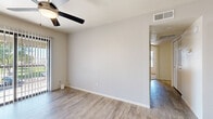 This single-story, 2-bedroom, 2-bathroom unit offers a thoughtfully designed layout that maximizes its compact footprint. The living area features light wood-look laminate flooring and a ceiling fan with integrated lighting, with sliding glass doors that allow natural light to fill the space. A connecting hallway leads to the rest of the unit, tying together each room seamlessly.

The kitchen is outfitted with white shaker-style cabinetry, light stone-finish countertops, and a full suite of stainless steel appliances, including a range, over-the-range microwave, and refrigerator. The clean, neutral palette gives the kitchen a modern, functional feel.

Both bedrooms feature plush wall-to-wall carpeting and ceiling fans, creating comfortable, relaxed retreats. The primary bedroom includes a built-in closet with double bi-fold doors and shelving, while a window with vertical blinds provides natural light. The second bedroom is equally well-proportioned with its own window and easy access to the hallway.

The two bathrooms are finished consistently with white vanity cabinetry, speckled stone countertops, large mirrors, and combination tub-shower units. The clean white finishes throughout create a bright, tidy atmosphere. A hallway connects the entrance to all rooms, ensuring a practical and efficient flow throughout the entire space.