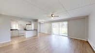 Located at 2610 Marigold Drive in Sauk Village, IL, this single-floor, 3-bedroom, 2-bathroom home offers a well-organized and functional layout. The open-concept living room and kitchen area serves as the heart of the home, featuring light wood laminate flooring, neutral gray walls, and a ceiling fan overhead. A large sliding glass door floods the living area with natural light and provides direct access to the outdoors, offering pleasant exterior views. The kitchen is equipped with ample white cabinetry, a white subway tile backsplash, dark countertops, a stainless steel sink, and white appliances, including a range and refrigerator. Tile flooring completes the kitchen space. Two hallways connect the living areas to the three bedrooms, each of which features light wood flooring, ceiling fans, and closets. The generously sized primary bedroom receives natural light through a large window. Both bathrooms are well-appointed; one features large-format marble-style tile surrounding the tub and shower, a white vanity, and tile flooring. Throughout the home, baseboard heating, clean white trim, and a consistent neutral color palette contribute to a bright, cohesive, and move-in-ready atmosphere.