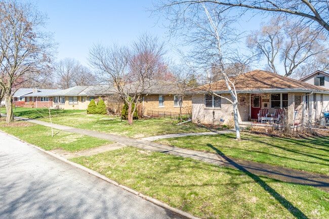 An orderly row of single-family homes made of brick along a residential street.