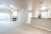 This single-floor residence offers a well-organized, open-concept layout that seamlessly connects the living area to the kitchen. The living room features plush wall-to-wall carpeting and a gas fireplace, creating a comfortable and inviting atmosphere. A peninsula-style kitchen counter with a dark laminate top and double stainless steel sink opens directly to the living space, making it ideal for everyday use and entertaining. The kitchen is equipped with stainless steel appliances, including a range, over-the-range microwave, and refrigerator, all complemented by white cabinetry and wood-look vinyl flooring that adds warmth to the space. The bedrooms are finished with soft carpeting and neutral-toned walls, with at least one bedroom featuring a ceiling fan with light fixture and a window that brings in natural light. The bathroom is clean and functional, featuring a full tub and shower combination with white tile surround, brushed nickel fixtures and accessories, and wood-look vinyl flooring that ties cohesively with the kitchen. Throughout the unit, a consistent neutral color palette and clean finishes create a cohesive, move-in-ready environment suitable for a range of lifestyles.