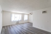 Located at 1749 N Serrano Ave in the desirable Los Feliz neighborhood of Los Angeles, this single-floor unit offers a clean, functional layout with consistent wood-style flooring running throughout the entire space. The open living area is bright and airy, featuring large windows with vertical blinds that allow abundant natural light, a ceiling fan, a wall-mounted AC unit, and a textured ceiling. The galley-style kitchen is efficiently designed with ample upper and lower cabinetry in a neutral gray finish, stone-look countertops, a double stainless steel sink, a dishwasher, a coil-top electric range, a microwave, and a full-size refrigerator — all in white. The bedroom is generously sized, featuring mirrored sliding closet doors that enhance the sense of space, a window for natural light, and the same wood-style flooring found throughout. The bathroom includes a vanity with stone-look countertops, under-sink storage, and a framed mirror with overhead lighting. A hallway connects the rooms, maintaining a straightforward and practical flow. The overall ambiance is bright, neutral, and well-maintained, offering a comfortable living environment in a prime Los Angeles location.