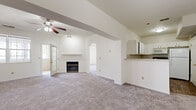 Located at 247 Marcliffe Dr in Valparaiso, Indiana, this home offers a well-designed layout with comfortable living spaces throughout. The expansive main living area is a standout feature, boasting vaulted ceilings, a ceiling fan, and a fireplace framed by a clean white mantel. Natural light flows in through large windows, and a French door adds an elegant touch. An arched passageway connects the living area to additional rooms, creating a sense of openness and flow. A half-wall with a pendant light defines the transition to a dining or flex space, adding architectural character. The kitchen is outfitted with white cabinetry, light countertops, a mosaic tile backsplash, wood-look flooring, and includes a gas range, built-in microwave, and refrigerator. The bedrooms are generously sized with plush carpeting and ceiling fans, with one bedroom featuring a large multi-pane window overlooking the neighborhood. The bathroom includes a full tub and shower combo, tile flooring, a white vanity, and a large mirror. Carpeted stairs lead between levels, finished with a sleek white handrail. The home presents a neutral, move-in-ready palette throughout.