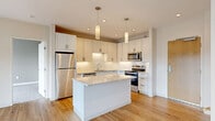 Located on Larchmere Boulevard in Cleveland's vibrant Larchmere neighborhood, this thoughtfully designed 2-bedroom, 2-bathroom residence offers a clean, contemporary aesthetic throughout. The open-concept living and kitchen area serves as the heart of the home, showcasing light hardwood flooring that flows seamlessly from room to room. Large sliding glass doors flood the living space with natural light and open directly onto a private balcony, offering pleasant views of the surrounding neighborhood.

The kitchen is a standout feature, equipped with white shaker cabinetry, subway tile backsplash, stone countertops, a center island with pendant lighting, and a full suite of stainless steel appliances. It is both functional and stylish, ideal for everyday cooking and entertaining.

Both bedrooms are comfortably sized, with the primary bedroom offering ample space and its own dedicated closet. The secondary bedroom features plush carpeting, a ceiling fan, and large windows that invite natural light. Three closets throughout the unit provide generous storage. Each bathroom is finished with tile flooring, shaker-style vanities with stone countertops, and frameless mirrors. The overall ambiance is bright, modern, and move-in ready.