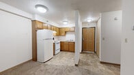 Located at 101 Riverside Dr SE in Saint Cloud, Minnesota, this one-bedroom, one-bathroom unit offers a practical and well-organized single-floor layout. The combined kitchen and living area serves as the heart of the unit, with the kitchen featuring warm oak cabinetry, ample upper and lower cabinet storage, a double-basin sink, and white appliances including a refrigerator and electric range. The tile flooring in the kitchen provides a durable, easy-to-clean surface, while a textured ceiling adds a classic touch throughout the space. A defined entryway near the kitchen offers a welcoming transition into the unit. The living area flows seamlessly from the kitchen, featuring neutral carpet, white walls, and a baseboard heating system. Natural light enters through wood-trimmed windows, creating a bright and comfortable atmosphere. The spacious bedroom is generously sized with plush carpeting, a corner window that brings in ample daylight and outdoor views, and a baseboard heater for year-round comfort. A dedicated closet provides practical storage. The bathroom includes a full tub and shower combo with grab bar support, a wall-mounted sink, a toilet, and a built-in over-toilet shelving unit for additional storage, all finished with matching tile flooring consistent with the rest of the unit.