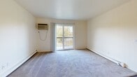 Located at 4705 N Breton Ct SE in Kentwood, Michigan, this single-floor unit offers a practical and comfortable layout designed for everyday living. The entry area transitions seamlessly between carpet and wood-look vinyl flooring, setting the tone for the rest of the space. The kitchen is well-appointed with white cabinetry, a gas range, dishwasher, and a sink beneath overhead cabinets, all complemented by light countertops and wood-look vinyl flooring that extends throughout the main living areas. The spacious living room features a sliding glass door that opens to a private balcony, offering pleasant outdoor views of surrounding greenery, along with a wall-mounted air conditioning unit and baseboard heating. The bedrooms are carpeted and bathed in natural light from large windows that frame tree-lined views. Each bedroom includes a dedicated closet with built-in shelving and hanging rods, providing ample storage. The full bathroom is finished with wood-look vinyl flooring, a single-sink vanity with warm wood cabinetry, and a tub/shower combination. Baseboard heating is present throughout, ensuring consistent comfort. The overall palette of neutral tones and clean walls creates a bright, move-in ready environment.