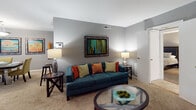 Located at 150 Hunt Club Lane in Raleigh, NC, this single-story residence offers a thoughtfully arranged floor plan designed for comfortable everyday living. The open layout connects key living areas seamlessly, as revealed by the overhead floor plan view.

The living room serves as the heart of the home, finished with neutral carpet and cool gray walls that create a calm, inviting atmosphere. Large windows allow natural light to fill the space, while the room's generous proportions comfortably accommodate a full seating arrangement and additional accent furniture. An adjacent dining area provides a natural transition for entertaining.

The kitchen features dark granite-style countertops, white upper cabinetry, lighter lower cabinets, and durable wood-look flooring. Stainless steel appliances and a dedicated laundry area enhance everyday functionality.

The bedrooms are carpeted and finished in soft gray tones. The primary bedroom is notably spacious and includes direct access to a walk-in closet with built-in organization. Additional bedroom space mirrors this comfortable scale and natural lighting. The bathroom is outfitted with a full tub and shower combination featuring clean white tile surround, offering a practical and well-maintained finish throughout.