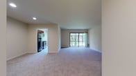 Located at 12215 Little Patuxent Parkway in Columbia, Maryland, this single-floor residence offers a well-organized and functional layout designed for comfortable living. The open living area is generously proportioned, featuring plush wall-to-wall carpeting and neutral tones throughout. A large sliding glass door floods the space with natural light and provides views of the surrounding greenery, while also offering access to an outdoor area. The galley-style kitchen is efficiently designed with rich wood cabinetry, granite-look countertops, a stainless steel refrigerator, electric range, built-in microwave, and a dishwasher, all set atop easy-care tile flooring. The bedrooms are carpeted and well-sized, offering ample room for furnishings. The primary bedroom includes a walk-in closet with built-in shelving and is accompanied by an en-suite bathroom featuring a glass-enclosed shower and tile surround. A second full bathroom includes a soaking tub with tiled walls, a vanity, and tile flooring. The residence is finished with clean white trim, recessed lighting, and a consistent neutral color palette that lends the space a bright and move-in-ready feel throughout.