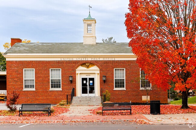 The post office in Fort Thomas is a historic building flanked by oaks and benches.