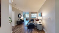 Located at 5654 Owens Dr in Pleasanton, California, this single-story residence offers a thoughtfully designed layout with a cohesive, contemporary aesthetic carried throughout every room. Rich hardwood-style flooring flows continuously across the living areas, complementing the warm neutral palette of the walls and crown molding detailing that adds a refined architectural touch.

The living room is a welcoming, generously proportioned space, featuring large windows dressed with patterned valances that allow abundant natural light to fill the room. A dedicated sitting area provides additional flexibility for entertaining or relaxing. The open layout connects seamlessly to a dining area and a well-equipped kitchen outfitted with white cabinetry, dark countertops, stainless steel appliances including a gas range, microwave, and dishwasher, and a central column that adds architectural character.

Multiple bedrooms are present, each offering a calm, restful atmosphere. One bedroom features direct outdoor access through a glass-panel door, while another benefits from large windows with views of surrounding greenery. The primary bathroom includes a wide double-sink vanity with dark countertops and ample cabinetry, while a secondary bathroom features a tub-shower combination. The overall ambiance is polished, comfortable, and move-in ready.