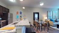 This one-bedroom, one-bathroom residence is thoughtfully designed to maximize both comfort and functionality within a well-appointed single-floor layout. The open-concept living and dining area flows seamlessly from the kitchen, creating a cohesive and inviting atmosphere ideal for everyday living and entertaining. The kitchen features a granite-topped breakfast bar with bar seating, a stainless steel sink, and pendant lighting that adds a stylish focal point overhead. The adjoining dining area accommodates a full dining table and chairs, making it a functional and social hub of the home. Warm hardwood-style flooring extends throughout the main living areas, grounding the space with a sense of warmth and continuity. Neutral-toned walls provide a versatile backdrop that complements a variety of décor styles, while flush-mount and pendant lighting fixtures ensure the space is well-lit throughout. The overall ambiance is modern and clean, with thoughtful design details that elevate the everyday living experience. This residence offers a practical yet refined layout suited for individuals or couples seeking a well-designed, move-in-ready home.