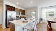 Located at 67 Old Amboy Rd in Old Bridge, NJ, this thoughtfully designed single-floor residence combines modern aesthetics with functional living. The open-concept kitchen is a standout feature, showcasing rich dark wood cabinetry, stainless steel appliances including a gas range, microwave, and French door refrigerator, complemented by a subway tile backsplash and a built-in wine rack. A generous white quartz island with bar seating serves as the heart of the space, flowing seamlessly into the dining and living areas. Light hardwood flooring runs throughout, enhancing the warm, contemporary feel. The living room is filled with natural light from multiple large windows dressed in sheer white curtains, offering pleasant outdoor views of the surrounding neighborhood. The bedrooms are well-proportioned and tranquil, each featuring large windows that invite abundant natural light and views of the tree-lined surroundings. The primary bathroom offers a dual-sink vanity with a quartz countertop, dark wood cabinetry, and a large mirror, while a second full bathroom includes a single vanity and a tub-shower combination. A private exterior door from the kitchen provides direct outdoor access, adding to the overall convenience and livability of this refined modern residence.
