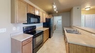 This well-appointed two-bedroom, two-bathroom home in Sioux Falls, SD offers a comfortable and functional single-floor layout. The open-concept living area seamlessly connects the kitchen, dining, and living spaces, creating an inviting atmosphere filled with natural light from a large window and a sliding door that opens to a private balcony. The kitchen is equipped with black appliances, including a range, microwave, and refrigerator, complemented by warm wood-toned cabinetry, light countertops, and track lighting overhead. A peninsula with a sink bridges the kitchen and living space, enhancing the open flow.

Both bedrooms feature plush carpeting, neutral-toned walls, and windows that bring in natural light and neighborhood views. The spacious primary bedroom includes a generous walk-in closet with dual wire shelving systems. The two bathrooms are finished with wood vanities, light countertops, and framed mirrors. A dedicated laundry room houses a stacked washer and dryer unit alongside additional cabinetry and counter space for added convenience. With five closets throughout, storage is plentiful. The textured ceilings and consistent neutral color palette lend a cohesive, move-in-ready feel to the entire home.