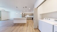 Located at 3875 W Dobbins Rd in Laveen, Arizona, this 900-square-foot apartment features 2 bedrooms, 2 bathrooms, and a single-level floor plan designed for modern living. The open-concept kitchen and living area is anchored by a large granite-topped island with pendant lighting, complemented by flat-front wood-toned cabinetry, a subway tile backsplash, and a full suite of stainless steel appliances. Light wood-style flooring flows throughout the main living areas, enhancing the bright, airy ambiance. The living room includes a ceiling fan and sliding glass doors opening to a private balcony with outdoor views. The primary bedroom spans 140 square feet with sliding glass door access to the balcony, light hardwood-style flooring, and a spacious walk-in closet featuring built-in shelving and dual hanging rods with plush carpeting. The primary bathroom offers a dual-sink granite vanity with wood-toned cabinetry. The second bedroom is carpeted, includes a ceiling fan, a window with natural light, and its own closet. Both bathrooms feature wood-look tile flooring. An in-unit laundry area is also present, adding everyday convenience to this well-appointed home.