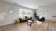 Located at 1321 N Lincoln Ave in Urbana, IL, this single-story unit offers 1,040 square feet of living space across four bedrooms and two bathrooms. The open living room features light wood-style flooring, a large window providing generous natural light and outdoor views, a ceiling fan, and a textured ceiling. The kitchen is equipped with white shaker-style cabinetry, granite countertops, a stainless steel sink, and a stainless steel dishwasher, complemented by light wood-style flooring. Both bathrooms include granite countertops, white cabinetry with brushed nickel hardware, and wood-style flooring; one bathroom features a double-sink vanity with overhead lighting, while the second includes a shower-tub combination. The four bedrooms are carpeted and include sliding mirrored closet doors in the primary bedroom, which also offers direct access to a bathroom. Additional rooms include a dedicated laundry room with a full-size washer and dryer, and a hallway connecting all spaces. Neutral wall tones and consistent finishes throughout give the unit a cohesive, modern aesthetic.