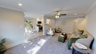 Located at Fairfield Courtyard at Bayport in Bayport, NY, this single-floor residence offers a thoughtfully designed open-concept layout that seamlessly connects the main living areas. The expansive living room features soft carpeting, crown molding, recessed lighting, and a ceiling fan, creating a comfortable and well-lit environment. Natural light flows generously throughout the space, enhancing the warm, neutral color palette.

The kitchen is outfitted with crisp white shaker-style cabinetry, a marble-look tile backsplash, stainless steel appliances including a gas range, built-in microwave, dishwasher, and French door refrigerator, all complemented by hardwood-style flooring. An adjacent dining area provides a bright, dedicated space for meals.

The bedroom is generously proportioned with plush carpeting, crown molding, a ceiling fan, and large windows that invite natural light. It includes a stacked in-unit washer and dryer conveniently tucked within a closet, alongside additional built-in closet storage. The bathroom features a white vanity with a marble-style countertop, subway tile wainscoting, and a well-lit mirror cabinet, delivering a clean and refined finish throughout.