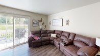 Located on Highbrook Court in Hudsonville, Michigan, this three-floor home offers a thoughtfully organized layout across its levels. The main floor features a welcoming living room with wood-look flooring, neutral walls, and a sliding glass door that opens to the outdoors, filling the space with natural light. The kitchen is well-equipped with white cabinetry, stainless steel appliances including a refrigerator, electric range, and built-in microwave, complemented by durable countertops and a double sink. An adjacent entry area connects seamlessly to the main living spaces. Two full bathrooms are present in the home — one featuring a vanity with white cabinetry and wood-look flooring, and another with a matching vanity and tub/shower combination. The upper level hosts multiple bedrooms, each with plush carpeting and natural light from windows with blinds. The bedrooms offer generous closet space and a clean, comfortable atmosphere. The lower level provides additional living space with carpeted flooring, neutral tones, and a cozy sectional layout — ideal for a recreation or media room. A staircase connects all three levels, visible in the dollhouse view, tying together a practical and comfortable home in a quiet Hudsonville neighborhood.
