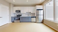 This 480-square-foot studio apartment is located at 121 N 2nd St in Philadelphia's historic Old City neighborhood. The single-floor unit features an open-concept layout with light wood-style flooring throughout the main living area, neutral gray walls, and a ceiling-mounted HVAC unit for year-round climate control. Multiple windows allow natural light to fill the space, creating a bright and airy atmosphere.

The modern kitchen is well-appointed with two-tone cabinetry — white upper cabinets and slate-blue lower cabinets — complemented by a clean white countertop and a tiled backsplash. Stainless steel appliances include a full-size refrigerator, electric range, built-in microwave, and dishwasher, all finished with recessed lighting overhead.

The bathroom features large-format dark tile flooring, a full soaking tub with shower, a navy blue vanity with a light countertop, and recessed lighting, delivering a clean, contemporary aesthetic. A dedicated closet with louvered double doors provides practical storage within the living area. The unit's efficient, thoughtfully designed layout makes excellent use of its 480 square feet, offering a functional and stylish living environment in the heart of Philadelphia.