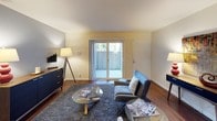 This single-floor residence showcases a cohesive mid-century modern aesthetic throughout its thoughtfully designed layout. Rich hardwood-style flooring flows through the main living areas, complementing neutral wall tones accented by carefully curated artwork.

The living room is a welcoming space centered around a sliding glass door that opens to a private outdoor patio, allowing natural light to fill the room. A plush area rug, glass coffee table, and comfortable seating create an inviting atmosphere.

The dining area features additional wall space for artwork, with a sleek dark dining table and retro-style seating completing the look. A secondary room, highlighted by a bold yellow accent wall and carpeted flooring, offers flexible use as a sitting room or additional bedroom, complete with a reach-in closet.

The primary bedroom is generously proportioned, featuring a soft blue accent wall, carpet flooring, a large window overlooking greenery, and a walk-in closet. Two full bathrooms serve the residence, each equipped with a soaking tub and shower combination, granite-topped vanities, and hardwood-style flooring.

The galley-style kitchen is efficiently designed with granite countertops, white cabinetry, stainless steel appliances, and ample storage, making it both practical and visually appealing.