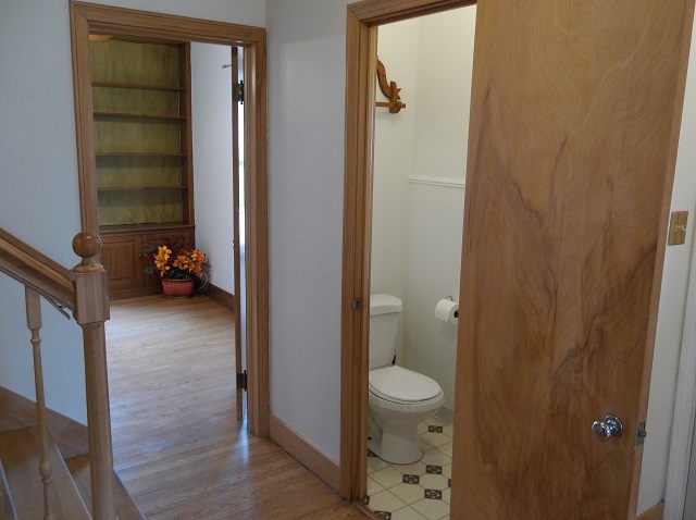 On the other side of the front entrance is the half bath and office with built-in wood bookshelves. - 742 E Ford Ave