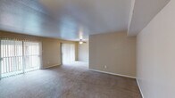 This single-story residence in Houston, TX offers a practical and well-organized layout across one floor. The living area is generously proportioned, featuring neutral beige walls, plush wall-to-wall carpeting, and a textured ceiling. A ceiling fan with a light fixture provides both comfort and illumination, while sliding glass doors fitted with vertical blinds open to the exterior, allowing natural light to fill the space. The entry area transitions seamlessly into the main living zone, which offers ample room for a variety of furniture arrangements.

The galley-style kitchen is efficiently designed, featuring white cabinetry on both sides, dark laminate countertops, wood-look flooring, and white appliances including a refrigerator, electric range, and dishwasher. A double-basin sink is positioned beneath overhead cabinets, maximizing storage and functionality throughout the compact but well-equipped space.

The bedroom is comfortably sized with soft carpeting, a ceiling fan, and two windows fitted with blinds that provide natural light and exterior views. The full bathroom includes a wide vanity with dark countertops, white cabinetry, a large mirror with overhead lighting, wood-look flooring, and a full tub-shower combination.
