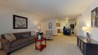 Located on White Oak Circle in Menomonee Falls, Wisconsin, this single-floor residence features a thoughtfully designed open layout that connects its primary living areas with ease. The spacious living room is carpeted and anchored by a large sliding glass door fitted with vertical blinds, allowing natural light to fill the space. The open flow guides seamlessly toward a dining area and into the kitchen, which features warm oak cabinetry, tile flooring, a double sink, and white appliances including a refrigerator and dishwasher — providing a practical and efficient workspace.

The primary bedroom is generously sized with plush carpeting, a natural window, and ample room for furniture arrangement. A second room, currently configured as a home office, offers flexible use with carpeted floors and a window. The full bathroom includes a warm oak vanity with a wide countertop, tile flooring, and a tub-shower combination. Throughout the residence, consistent neutral tones, carpet in living areas, and wood-toned trim create a cohesive and comfortable atmosphere well-suited to everyday living.