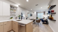 Located at 204 Wagaraw Rd in Hawthorne, NJ, this single-floor residence features a thoughtfully designed open-concept layout with contemporary finishes throughout. The kitchen is a standout, boasting two-tone cabinetry with warm wood lower cabinets and crisp white upper cabinets, white quartz countertops, a subway tile backsplash, stainless steel appliances including a gas range, built-in microwave, refrigerator, and dishwasher, and open shelving for added functionality. A central island with a deep single-basin sink flows seamlessly into the dining and living areas, creating an ideal space for entertaining. The living room is bright and welcoming, featuring recessed lighting, light hardwood-style flooring, and large windows that allow natural light to fill the space. The bedroom offers generous proportions with large windows, light-filtering shades, and the same consistent flooring. The bathroom is finished with large-format tile flooring and a tub-shower combination. A dedicated laundry closet houses a stacked full-size washer and dryer. Throughout the unit, a neutral color palette, recessed lighting, and clean architectural lines contribute to a cohesive modern aesthetic.