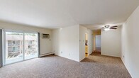 Located at 50 Jordan Dr in Whitehall, PA, this one-bedroom, one-bathroom unit offers a well-organized single-floor layout designed to maximize every square foot. The entry opens into a carpeted living area bathed in neutral tones, with a ceiling fan overhead and a sliding glass door leading to a private balcony that overlooks the landscaped community grounds and surrounding greenery. The layout flows seamlessly into a separate dining room and a well-appointed kitchen, which features light wood cabinetry, granite-style countertops, stainless steel appliances including a gas range and built-in microwave, and a decorative tile backsplash. Natural light pours in through the kitchen's double windows. The generously sized primary bedroom is carpeted, bright, and includes two closets — one a standard closet and the other a walk-in — providing excellent storage. A hallway connects the main living spaces and leads to an additional closet for extra convenience. The full bathroom is clean and functional, finished with wood-look flooring, a tub and shower combination with sliding glass doors, and a window for natural ventilation. Baseboard heating is present throughout the unit, ensuring year-round comfort.