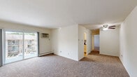 Located at 50 Jordan Dr in Whitehall, PA, this one-bedroom, one-bathroom unit offers a well-organized single-floor layout designed to maximize every square foot. The entry opens into a carpeted living area bathed in neutral tones, with a ceiling fan overhead and a sliding glass door leading to a private balcony that overlooks the landscaped community grounds and surrounding greenery. The layout flows seamlessly into a separate dining room and a well-appointed kitchen, which features light wood cabinetry, granite-style countertops, stainless steel appliances including a gas range and built-in microwave, and a decorative tile backsplash. Natural light pours in through the kitchen's double windows. The generously sized primary bedroom is carpeted, bright, and includes two closets — one a standard closet and the other a walk-in — providing excellent storage. A hallway connects the main living spaces and leads to an additional closet for extra convenience. The full bathroom is clean and functional, finished with wood-look flooring, a tub and shower combination with sliding glass doors, and a window for natural ventilation. Baseboard heating is present throughout the unit, ensuring year-round comfort.