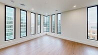 This sleek 850 square foot apartment, located on the 8th floor of 111 Lyon St NW in Grand Rapids, MI, offers a harmonious blend of modern design and urban living. The space features two bedrooms and two bathrooms, with the primary bedroom boasting a generous 130 square feet. The open-concept floor plan seamlessly integrates the kitchen, living, and dining areas, creating a spacious and airy atmosphere.

The gourmet kitchen is a highlight, showcasing light wood cabinetry, stainless steel appliances, and a large island with a sink, perfect for both meal preparation and casual dining. Pendant lighting adds a touch of elegance, while the white quartz countertops provide a crisp contrast to the warm wood tones.

Floor-to-ceiling windows are a standout feature, flooding the space with natural light and offering breathtaking panoramic views of the Grand Rapids cityscape. The living area is particularly impressive, with a corner window configuration that maximizes the urban vistas.

Both bathrooms are designed with a modern aesthetic, featuring clean lines, wood vanities, and glass-enclosed showers. The bedrooms are well-proportioned, with ample closet space and large windows that continue the apartment's theme of abundant natural light.

Throughout the apartment, warm wood flooring unifies the space, creating a cohesive and inviting ambiance. Recessed lighting and a neutral color palette further enhance the contemporary feel of this urban oasis.