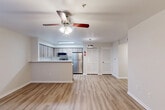 Located at 25469 Borough Park Drive in Spring, TX, this 2-bedroom, 1-bathroom single-story residence offers a functional and well-appointed layout. Light wood-style vinyl flooring runs throughout the home, creating a clean, cohesive look.

The open-concept living, dining, and kitchen area forms the heart of the home. The living room features a ceiling fan with integrated lighting and a window that brings in natural light. The kitchen is outfitted with light wood-tone cabinetry, white quartz-style countertops, stainless steel appliances including a refrigerator, electric range, and microwave, plus a double-basin sink. A peninsula counter provides additional workspace and separates the kitchen from the living and dining areas. A pendant light and built-in overhead fixture provide ample illumination.

Both bedrooms are comfortably sized, with neutral-toned walls, windows with blinds, and easy access to closets fitted with louvered bifold doors. The primary bedroom includes a ceiling fan. The bathroom features a full tub-shower combination with white tile surround.

Additional spaces include a laundry area, utility room, pantry, and hallway with multiple closets, providing strong storage capacity throughout. The layout is efficient and practical.