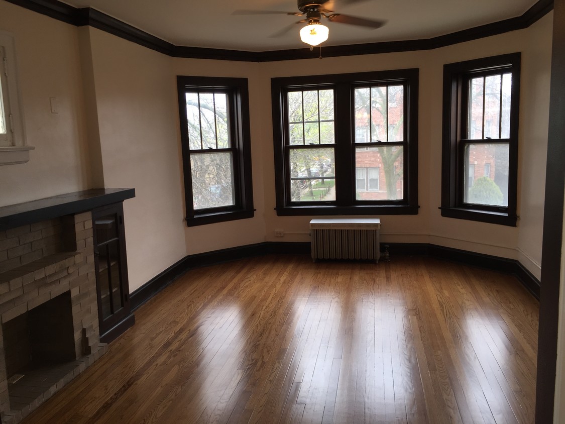 Las grandes ventanas withBay de la sala de estar y chimenea - Birchwood Apartments