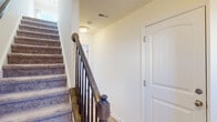 Located at 55 Yoe Dr in Red Lion, PA, this three-floor home offers a thoughtfully designed layout with consistent, quality finishes across every level. The entry foyer welcomes you with light-toned flooring and a staircase featuring a dark wood banister with decorative newel posts and carpeted treads, connecting all three floors seamlessly.

The kitchen is a functional highlight, showcasing rich dark wood cabinetry, granite countertops, and a full suite of stainless steel appliances including a refrigerator, range, microwave, and dishwasher. Light hardwood-style flooring and a window above the sink bring in natural light, while a sliding glass door in the adjacent dining area opens to a balcony with neighborhood views, further brightened by a classic chandelier overhead.

The living areas feature light hardwood-style flooring and ceiling fans, while bedrooms are finished with plush carpet and additional ceiling fans for comfort. Multiple windows flood these spaces with natural light and provide pleasant exterior views.

The bathroom is finished with matching granite countertops atop a dark wood vanity, a framed mirror with overhead lighting, and a walk-in shower with a clean, all-white surround. Hardwood-style flooring carries through here as well, maintaining a cohesive aesthetic throughout the home.