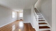 Located at 545 Alden Dr in Rahway, NJ, this multi-floor home spans three levels and offers a well-organized layout with a welcoming blend of classic character and functional living spaces. Rich, polished hardwood floors flow throughout the main and upper levels, reflecting natural light from multiple windows and lending warmth to every room.

The main floor features a bright living room with large windows, a radiator heating unit, and a classic staircase with white-painted balusters and dark wood treads. The dining room and kitchen round out the first floor, complemented by a patio for outdoor enjoyment. A hallway and closets provide practical storage throughout.

Upstairs, the spacious bedroom is well-lit by multiple windows fitted with blinds and includes a window air conditioning unit and radiator heating. A second versatile room serves as a den, also featuring hardwood floors and natural light. The full bathroom is neatly appointed with white tile flooring, a vanity with mirror, a bathtub, and a bright window.

The lower level includes an unfinished basement with painted concrete block walls and exposed piping, offering generous utility or storage potential. This home's consistent hardwood flooring, multi-zone layout, and classic architectural details make it a distinctive and practical residence in Rahway.