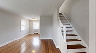 Located at 545 Alden Dr in Rahway, NJ, this multi-floor home spans three levels and offers a well-organized layout with a welcoming blend of classic character and functional living spaces. Rich, polished hardwood floors flow throughout the main and upper levels, reflecting natural light from multiple windows and lending warmth to every room.

The main floor features a bright living room with large windows, a radiator heating unit, and a classic staircase with white-painted balusters and dark wood treads. The dining room and kitchen round out the first floor, complemented by a patio for outdoor enjoyment. A hallway and closets provide practical storage throughout.

Upstairs, the spacious bedroom is well-lit by multiple windows fitted with blinds and includes a window air conditioning unit and radiator heating. A second versatile room serves as a den, also featuring hardwood floors and natural light. The full bathroom is neatly appointed with white tile flooring, a vanity with mirror, a bathtub, and a bright window.

The lower level includes an unfinished basement with painted concrete block walls and exposed piping, offering generous utility or storage potential. This home's consistent hardwood flooring, multi-zone layout, and classic architectural details make it a distinctive and practical residence in Rahway.