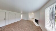 Located in University Place, WA, this 2-bedroom, 1-bathroom single-floor unit offers a clean, functional layout designed for comfortable everyday living. The kitchen is a standout feature, outfitted with crisp white cabinetry, ample counter space, a double basin sink, and white appliances including a range and refrigerator. Wood-look flooring runs throughout the kitchen and living areas, lending warmth and easy maintenance. A sliding glass door in the kitchen/living area opens to a private patio with a view of a grassy outdoor space, filling the room with natural light. Both bedrooms are carpeted in neutral tones and feature generous closets with classic six-panel bi-fold doors. The primary bedroom provides a comfortable sense of space, while the second bedroom includes a window with a neighborhood view and a baseboard heating unit. The full bathroom is neatly appointed with wood-look tile flooring, white vanity cabinetry, a tub/shower combo, and a well-lit mirror. A connecting hallway ties the layout together efficiently. Baseboard heating is present throughout, ensuring year-round comfort. The overall aesthetic is bright and neutral, with white walls and consistent finishes creating a cohesive, move-in ready environment.