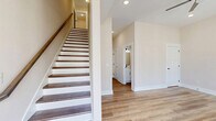 Located at 422 Centre St in Pleasant View, TN, this three-story townhome offers a well-designed layout across three distinct floors. The entry-level garage provides convenient parking and utility access, with staircase connectivity leading to the main living areas above.

The main floor serves as the heart of the home, featuring an open-concept kitchen and living area. The kitchen is appointed with white shaker cabinets, subway tile backsplash, light quartz countertops, and stainless steel appliances, including a side-by-side refrigerator and electric range. Light wood-tone luxury vinyl plank flooring flows throughout, complementing the neutral warm-beige wall tones and crisp white trim.

The upper floor hosts all three bedrooms, including a primary suite with a dedicated closet outfitted with built-in shelving and hanging rods. Soft carpet in the bedrooms contrasts with the hard flooring in common areas. Each bedroom benefits from natural light through double-hung windows with views of the surrounding neighborhood.

Five bathrooms are distributed across the home, featuring white vanities with black hardware accents, wood-look LVP flooring, and tub-shower combinations. Hallways connect the spaces cleanly, reinforcing the home's thoughtful, functional flow. The exterior presents a classic brick-and-board facade within a well-kept suburban streetscape.
