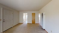 Located at 1401 Liberty St in El Cerrito, California, this single-story unit offers a practical and straightforward layout across several connected rooms. The living area is generously proportioned, featuring wall-to-wall carpeting, neutral cream-toned walls, and a large sliding window that invites natural light and provides views of the surrounding neighborhood. A wall-mounted heater unit serves the main living space, adding a functional element to the room. An entry area with a paneled white door and an adjacent window further brightens the space.

The kitchen is equipped with a freestanding electric range, an overhead exhaust hood, and upper cabinetry finished in a light tone. Light tile flooring runs throughout the kitchen, providing a clean contrast to the carpeted areas of the home. A pass-through opening connects the kitchen to adjacent spaces, enhancing the overall flow of the floor plan.

The bedrooms are carpeted and well-lit, each featuring windows that allow natural light to filter in. One bedroom benefits from a ceiling light fixture, while another offers a serene view of greenery outside.

The bathroom includes a combination tub and shower enclosed by sliding glass doors with chrome framing, complemented by tile flooring and a vanity with a white sink. The overall layout, as seen in the dollhouse view, presents a compact yet functional single-floor design well-suited for comfortable everyday living.