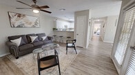 Located at 100 Windsor Lake Blvd in Brandon, Mississippi, this single-floor, 2-bedroom, 2-bathroom home offers a thoughtfully designed layout that balances comfort and functionality. The living room features light wood-style flooring, a ceiling fan, and neutral walls that create a bright, welcoming atmosphere. The kitchen is equipped with white cabinetry, light countertops, and a stainless steel refrigerator, complemented by the same wood-style flooring that flows throughout the main living areas. Adjacent to the kitchen, the dining area benefits from a large window that frames a pleasant outdoor view, filling the space with natural light beneath a pendant light fixture. The primary bedroom is generously sized, featuring plush carpet flooring, a ceiling fan, and a window with outdoor views, alongside a spacious walk-in closet with wire shelving for ample storage. The second bedroom also features carpet flooring and a window allowing natural light. Both bathrooms include wood-style tile flooring and clean, modern finishes with built-in cabinetry. The overall design maintains a consistent neutral palette throughout, creating a cohesive and inviting living environment.