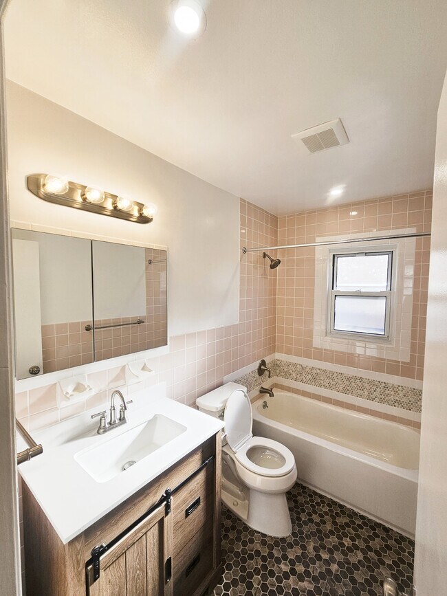Baño recién reformado con luz sobre el lavabo y sistema de ventilación. - 2050 Hazen St