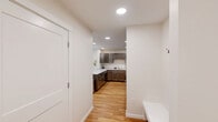 Located at 375 Autumn Pond Way in Essex Junction, Vermont, this well-appointed two-bedroom, two-bathroom residence offers a thoughtfully designed single-floor layout with modern finishes throughout. The living room serves as the heart of the home, featuring warm hardwood flooring, a bold teal accent wall, and generous natural light streaming through large windows and a glass door that opens to a private balcony overlooking verdant tree views. The kitchen is outfitted with rich dark-toned cabinetry, white countertops, stainless steel appliances, and a peninsula with bar seating — ideal for casual dining and entertaining. Both bedrooms feature plush carpeting and stylish green accent walls, lending a cohesive and calming aesthetic. The spacious primary bedroom offers ample room and connects to dedicated closet space. The two bathrooms are finished with light tile flooring and clean white fixtures; one includes a shower-tub combination with a window view of the surrounding landscape, while the other features a walk-in shower and a white vanity. A connecting hallway and closet complete the functional layout. The residence blends contemporary design with a warm, natural palette, creating a comfortable and inviting living environment.