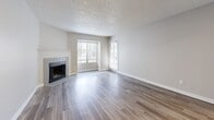 Located at 2864 Dublin Blvd in Colorado Springs, CO, this well-appointed one-bedroom, one-bathroom unit offers a thoughtfully designed single-level layout. The open-concept living and dining area is a standout feature, showcasing wood-style laminate flooring, a textured ceiling, and a tile-surround fireplace that serves as a warm focal point. Large windows and a sliding glass door bathe the space in natural light while providing direct access to a private outdoor balcony. The kitchen is outfitted with white shaker cabinetry, granite-style countertops, stainless steel appliances including a refrigerator and microwave, and a breakfast bar that connects seamlessly to the living and dining area. A central hallway links all rooms, and includes a built-in storage unit for added convenience. The bedroom features plush carpeting, a closet, and a sliding glass door opening to an outdoor space. A utility room with in-unit washer and dryer hookups is conveniently accessible from the bedroom. The bathroom is finished with a granite-topped vanity, white cabinetry, and a full tub-shower combination with wood-style tile flooring. Two closets provide ample storage throughout the unit.