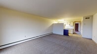 Located at 2550 Second St in Cuyahoga Falls, Ohio, this one-bedroom, one-bathroom unit offers a well-organized single-floor layout that maximizes every square foot of its comfortable living space. The open-concept living and kitchen area forms the heart of the unit, where plush carpeting in the living zone transitions seamlessly to wood-look flooring in the kitchen. A pass-through counter connects the two spaces, reinforcing the open feel. The kitchen is thoughtfully appointed with granite countertops, a subway tile backsplash, two-tone cabinetry in white and dark wood, a double stainless steel sink, and white appliances including a range and refrigerator. Natural light pours into the living area through a large sliding glass door that opens onto a private balcony, framed by exposed brick accent walls that add warmth and character. The bedroom features rich hardwood flooring, a baseboard heating unit, and generous closet space provided by multiple bifold-door closets. A hallway connects the main living areas to four total closets, offering exceptional storage throughout. The full bathroom includes tile flooring, a vanity with a single sink, a large mirror, and a tub/shower combination with white tile surround. Baseboard heating is present throughout the unit.