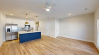 This contemporary residence at 250 Foster Dr, McDonough, GA, offers 1140 square feet of living space across two floors. The home boasts four bedrooms, including a generously sized 160 square foot primary bedroom, and three bathrooms. The ground floor spans 540 square feet, while the upper level provides 600 square feet of space.

The interior showcases a modern aesthetic with neutral tones and high-quality finishes. Light-colored walls and ceilings create an airy atmosphere, complemented by warm, natural wood flooring throughout most rooms. Large windows with white blinds allow ample natural light to flood the spaces.

The kitchen is a highlight, featuring crisp white cabinetry, stainless steel appliances, and a striking blue island with a light-colored quartz countertop. Gold-toned fixtures and pendant lighting add a touch of elegance. The open-concept design seamlessly integrates the kitchen with the living areas, ideal for entertaining.

Bathrooms are designed with functionality and style in mind, incorporating elements such as glass shower enclosures, modern vanities, and coordinated fixtures. The home also includes practical amenities like a garage with an automatic door opener and ample storage space.

Overall, this property combines contemporary design with comfortable living spaces, offering a turnkey solution for those seeking a modern home in a desirable Georgia location.
