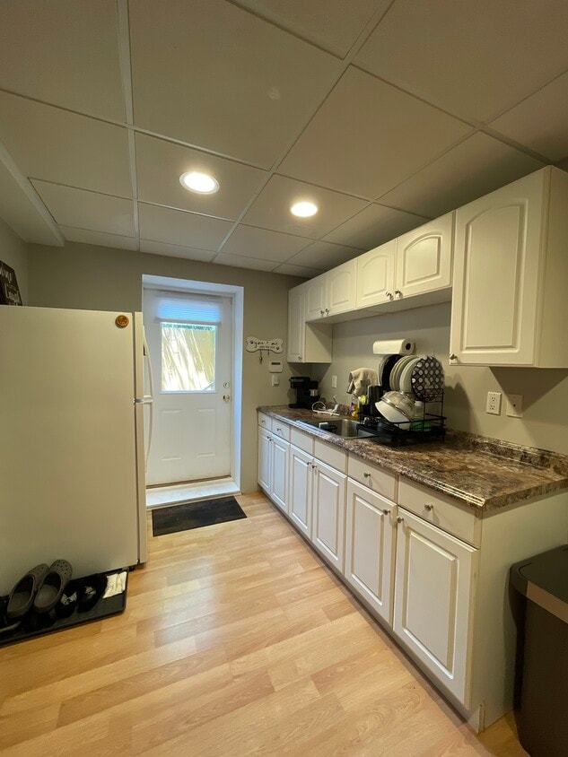 The private entrance leads into the kitchen with a farmhouse sink and fridge. - 18 Old Neck Ct