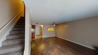 Located at 5757 Wooldridge Rd in Corpus Christi, TX, this two-story home offers a well-organized layout with functional living spaces across both levels. The main living area is generously sized, featuring rich wood-look flooring, a textured ceiling, and a classic brick fireplace that serves as a focal point of the room. A ceiling fan adds comfort, while vertical blinds along a sliding glass door allow natural light to fill the space. The kitchen is connected to the living area via a pass-through window, creating an open and communicative flow. It is equipped with warm-toned wood cabinetry, granite countertops, and a double stainless steel sink. A staircase with carpeted treads leads to the upper level, where the bedrooms are found. Bedrooms feature plush carpet flooring, ceiling fans, and textured ceilings. The bathrooms are well-appointed, showcasing rich wood vanities topped with granite countertops and stylish vessel sinks framed by elegant mirrors with accent lighting. One bathroom includes a full tub-shower combination. The home's neutral color palette, consistent finishes, and practical layout make it a comfortable and move-in ready residence.