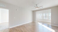 Located at 500 Liberty Ln in Fort Walton Beach, FL, this single-story, 2-bedroom, 2-bathroom home offers a well-designed open-concept layout with a clean, modern aesthetic throughout. The combined kitchen and living area serves as the heart of the home, featuring light hardwood-style flooring, neutral gray walls, and a ceiling fan that enhances airflow and comfort. The kitchen is outfitted with gray shaker-style cabinetry, granite countertops, a central island, stainless steel appliances including a refrigerator with ice maker, range, microwave, and dishwasher, and stylish pendant lighting overhead. Natural light filters in through blinds-equipped windows, brightening the open living space. Both bedrooms are carpeted and generously sized, each with ceiling fans and windows that invite natural light. The spacious primary bedroom includes a walk-in closet with wire shelving for ample storage. Both bathrooms feature granite-topped vanities with gray cabinetry, wood-style flooring, and walk-in showers with curved curtain rods. A dedicated laundry room houses a full-size washer and dryer alongside overhead wire shelving. Two closets and a hallway complete the functional, well-organized floor plan.