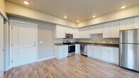 Located at 3619 Bill McDonald Pkwy in Bellingham, WA, this 2-bedroom, 1-bathroom unit offers a well-designed, single-floor layout that maximizes every square foot of its compact footprint. The kitchen is a standout feature, showcasing white shaker cabinetry extending to the ceiling, dark countertops, light wood-look flooring, and a full suite of stainless steel appliances including a range, microwave, dishwasher, and refrigerator. Recessed lighting throughout the kitchen and living area adds a clean, modern feel.

The living room opens to a private balcony through sliding glass doors, inviting natural light and outdoor views of the surrounding greenery. A ceiling fan overhead adds comfort and functionality.

Both bedrooms feature wood-look flooring, ceiling fans, and generous windows that frame pleasant outdoor scenery. The primary bedroom includes a closet with built-in shelving. The second bedroom also benefits from multiple windows and ample natural light.

The bathroom is finished with wood-look flooring, a tub/shower combo, and a vanity with a dark countertop and light blue cabinetry. A dedicated laundry area houses a full-size Whirlpool washer and dryer with overhead shelving, adding convenience to daily living.